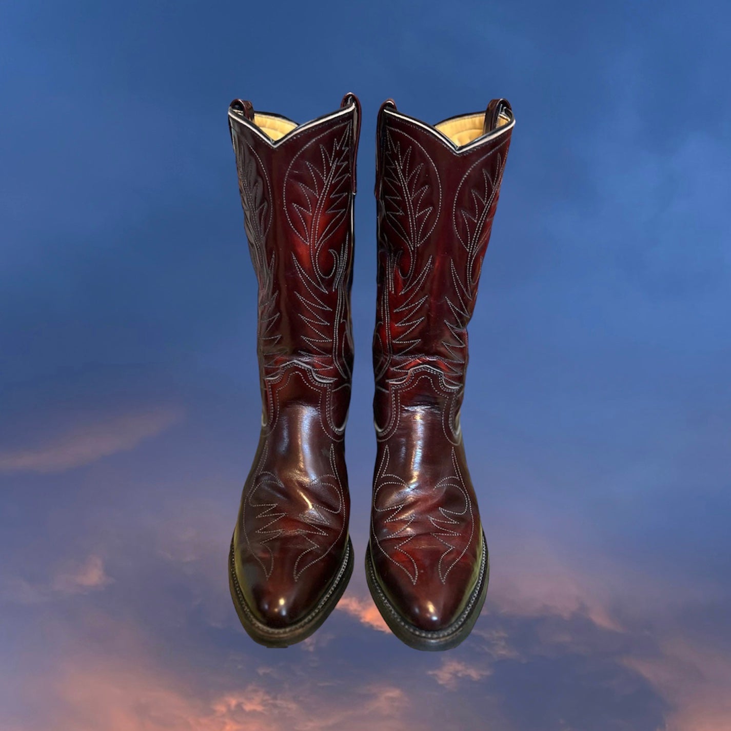Front view of dark reddish-brown western leather boots with white stitching. Good Kid Collective hand-picked this item.