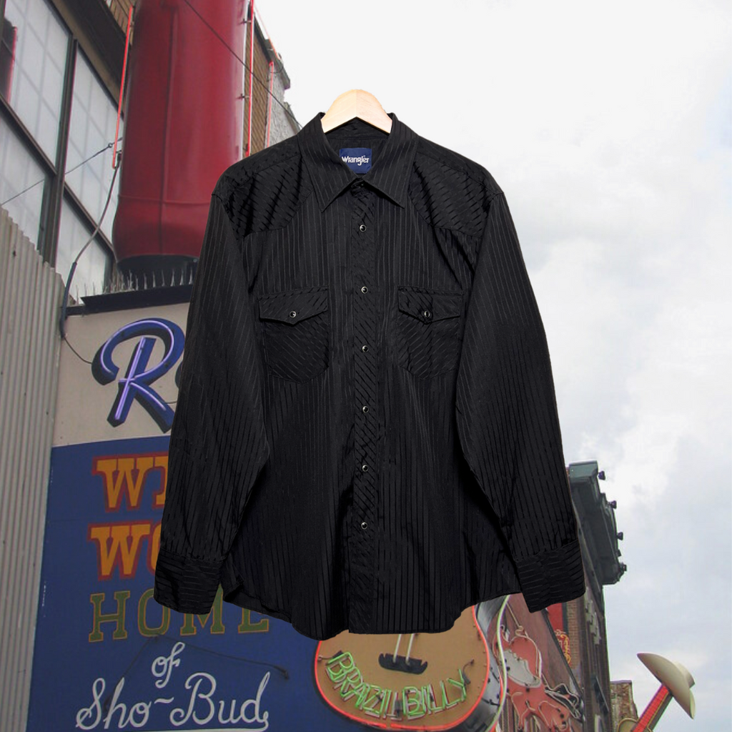 Front of black, western Wrangler button-up shirt w/ black snap buttons and subtle black stripes. Good Kid Collective hand-picked this item.